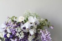 47 a romantic and chic spring wedding centerpiece of wisteria, iris and some fillers is a lovely idea for a refined spring wedding