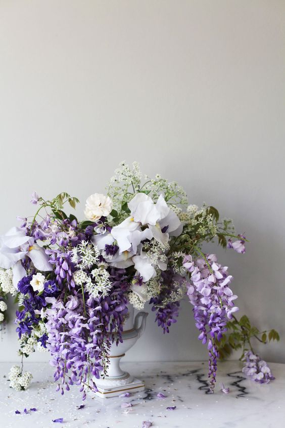 a romantic and chic spring wedding centerpiece of wisteria, iris and some fillers is a lovely idea for a refined spring wedding