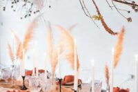 48 a boho wedding tablescape with a pastel runner, rust napkins, grasses, candles and a large installation with rust leaves, branches and pampas grass