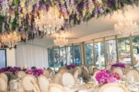 49 a sophisticated wedding reception space with greenery and wisteria hanging down, with fuchsia and purple blooms on the tables