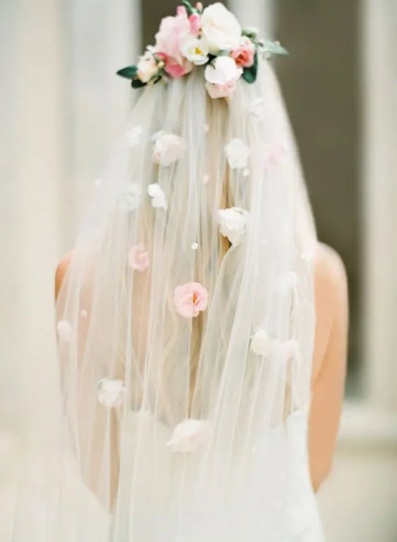 a veil with pearls and faux florals on the veil and its top looks very spring-like