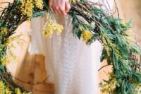 50 a lovely mimosa wedding wreath with evergreens is a creative idea for wedding decor, especially at a rustic wedding