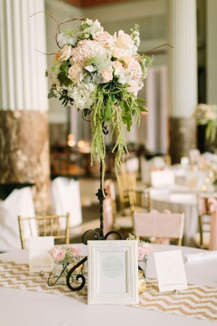 a refined tall wedding centerpiece of blush roses and hydrangeas, twigs, greenery and amaranthus is chic and cool