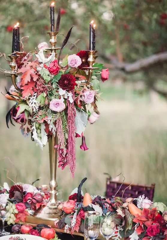 a Halloween wedding centerpiece of lush blooms, colorful leaves, cascading blooms and black candles