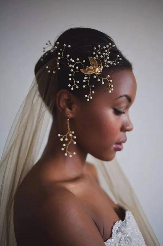 a bride wearing a gold veil and matching accessories with pearls and gold for a very sophisticated look