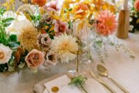 52 a bright fall wedding centerpiece of white and coral dahlias, orange mums, greenery, blush and white roses and bold fall leaves