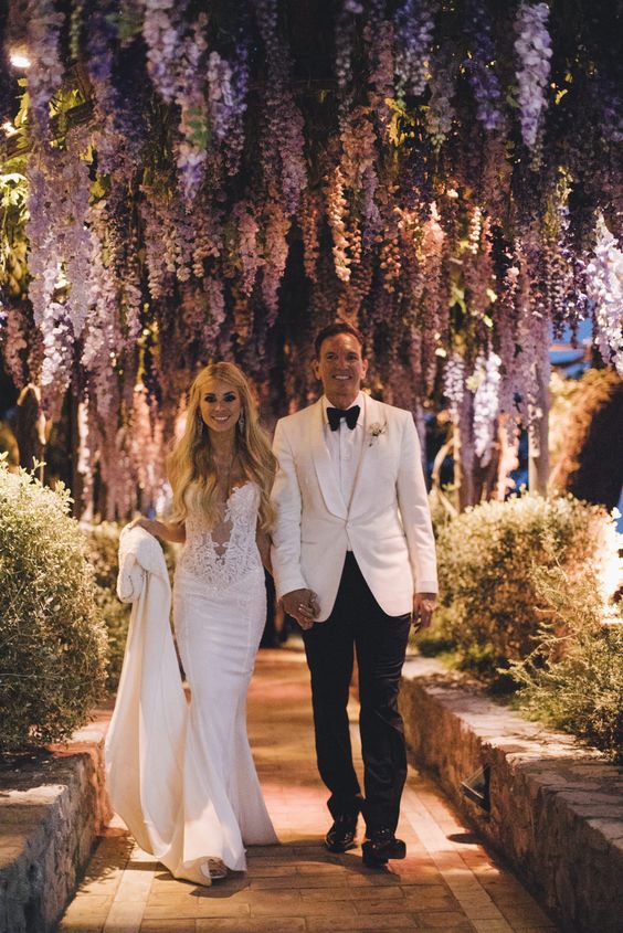 a wedding walkway with wisteria hanging over it and greenery around is a gorgeous idea for a wedding