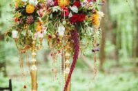 53 a colorful floral centerpiece of cascading blooms and greenery of various colors for a woodland wedding