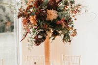 54 a textural tall floral centerpiece in a copper vase, with lots of various greenery, rust and burgundy blooms and dark foliage