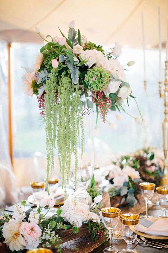 a tall wedding centerpiece of blush and white roses, green hydrangeas, greenery and green amaranthus is super chic