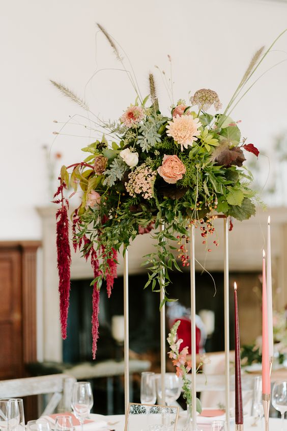 a tall wedding centerpiece of blush dahlias and roses, greenery and grasses and amaranthus is a lovely idea for the fall