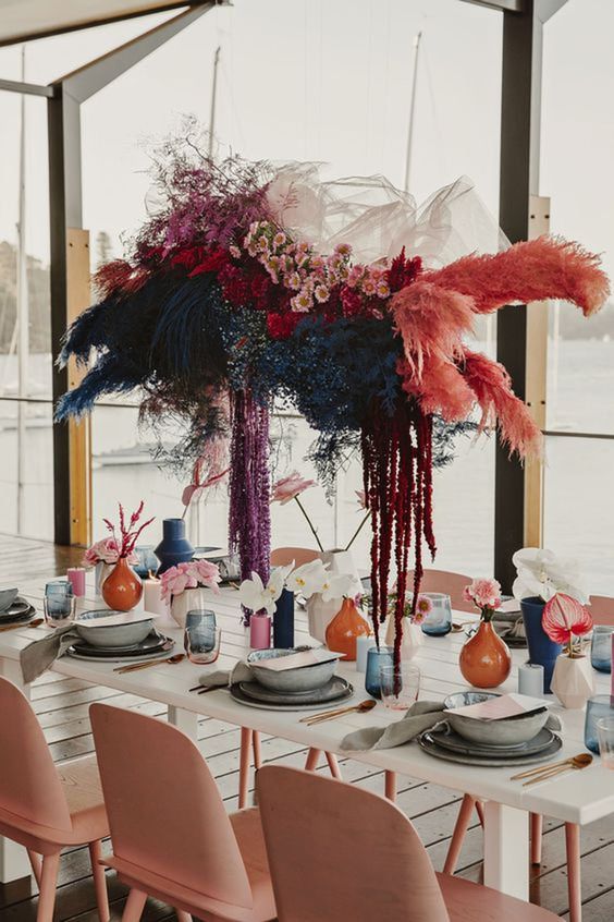 a bold overhead floral installation of pink blooms, dried flowers and grasses in various colors to make a statement