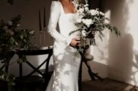 61 a modern plain mermaid wedding dress with a square neck, long sleeves with accented shoulders, a sash and a train is gorgeous for a modern wedding