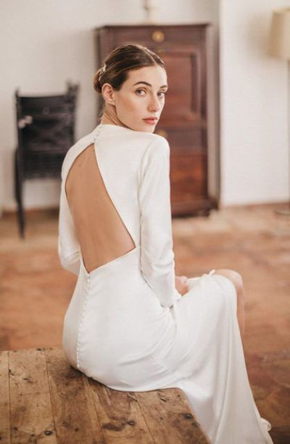 a modern plain wedding dress with a rhomb cutout back and long sleeves plus a row of buttons is a lovely and chic idea
