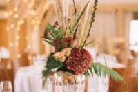 66 a mercury glass vase on a wood slice, bright blooms, greenery and pampas grass plus berries for a barn wedding