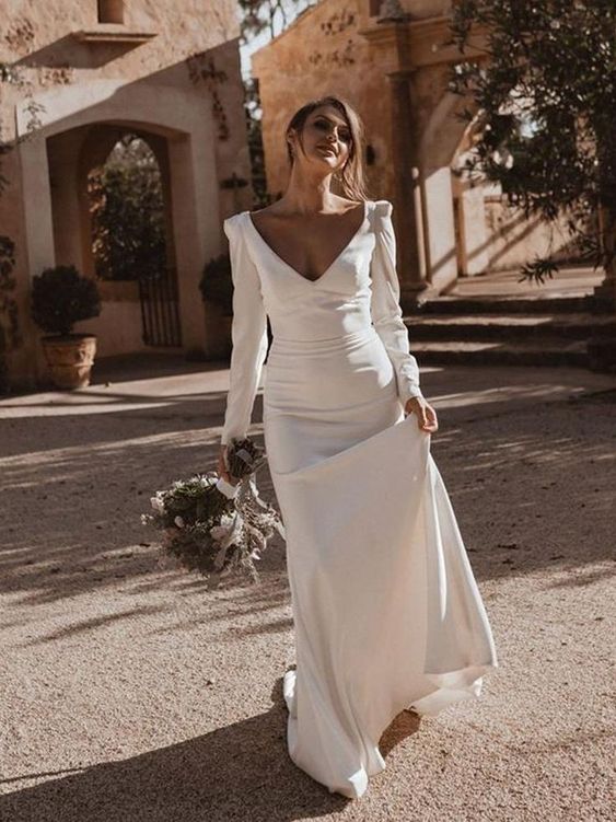 a romantic modern mermaid wedding dress with a deep neckline, long sleeves and a train is a lovely idea for a modern and romantic wedding