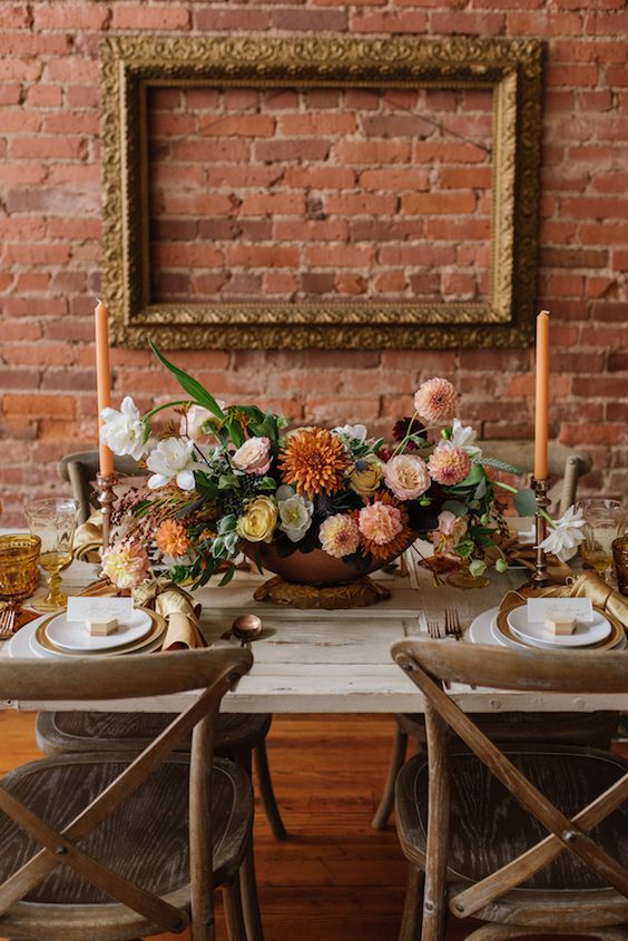 a sophisticated fall wedding centerpiece of blush mums, rust dahlias, white and yellow blooms and greenery is adorable