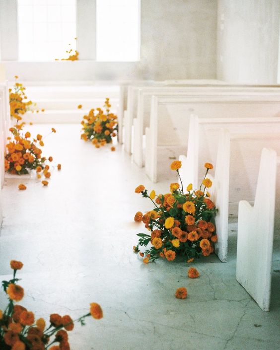 bold marigold wedding arrangements to line up the aisle are a cool idea for many wedding styles