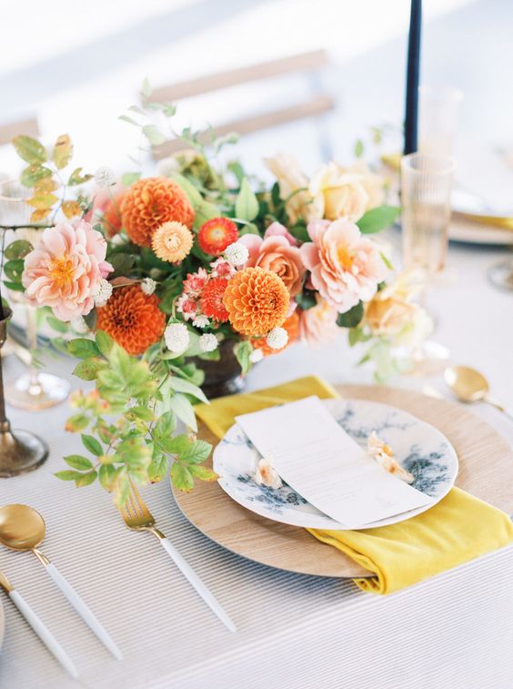 a vibrant fall wedding centerpiece of pink peonies, orange mums and other smaller fillers and greenery is a gorgeous idea
