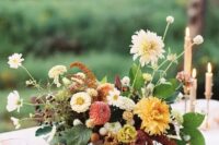 80 an elegant fall wedding centerpiece of red and orange dahlias, white blooms, berries, leaves and some fruit right on the table