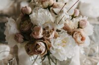 a beautiful and delicate wedding centerpiece of white and blush peonies, coffee-colored ones, lunaria and roses si a very romantic idea