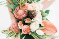 a beautiful bouquet with blush and peachy blooms, king protea and tropical leaves