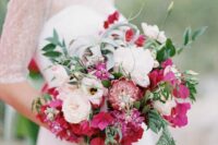 a beautiful wedding bouquet of white peonies and peony roses, bougainvillea, king protea, greenery for a summer wedding