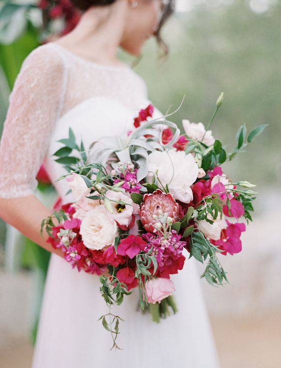 a beautiful wedding bouquet of white peonies and peony roses, bougainvillea, king protea, greenery for a summer wedding
