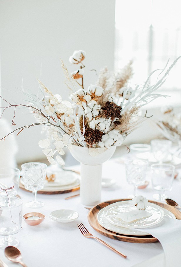 a beautiful wedding centerpiece of cotton branches, lunaria, branches and some dried berry branches is very delicate and chic