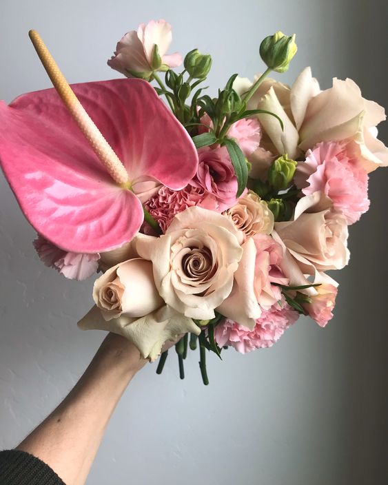 a blush and pink wedding bouquet of neutral and pink roses and carnations, a pink anthurium is a lovely idea