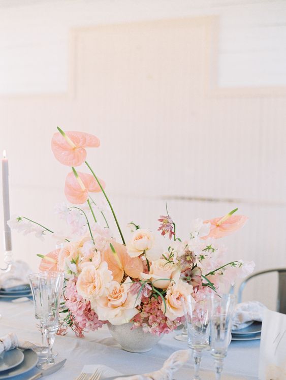 a blush wedding centerpiece of roses, hydrangeas, anthuriums is a chic and lovely idea for a garden wedding