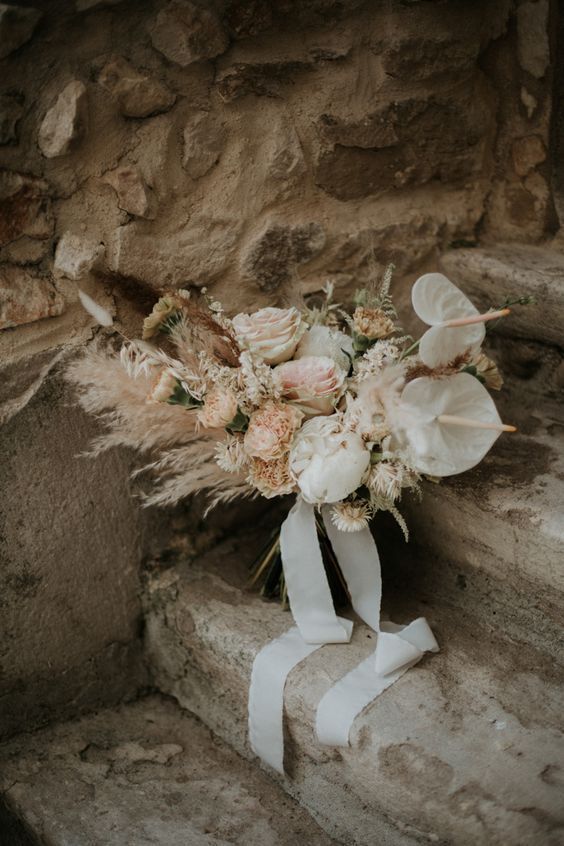a boho blush wedding bouquet of anthurium, roses, carnations, pampas grass and other grasses is adorable