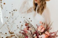 a boho wedding bouquet of pink anthurium, dried blooms, berries and grasses is a dreamy and cool idea for a boho bride