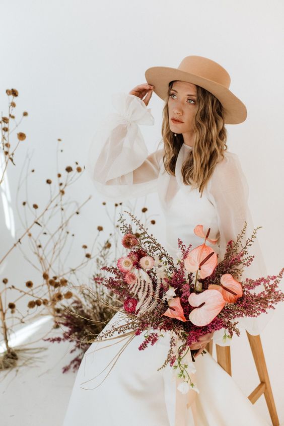a boho wedding bouquet of pink anthurium, dried blooms, berries and grasses is a dreamy and cool idea for a boho bride