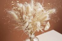a boho wedding centerpiece of lunaria, bunny tails, some fillers and dried grasses is a lovely and chic idea to rock