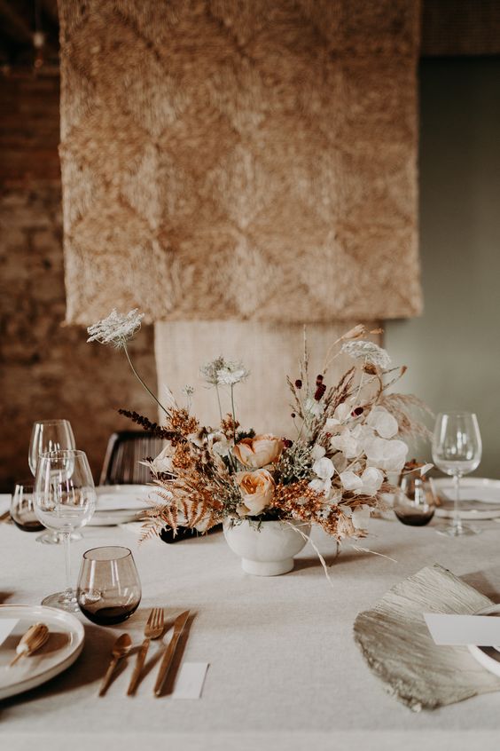 a boho wedding centerpiece of roses, lunaria, some dried grasses and leaves is a cool idea for a boho wedding