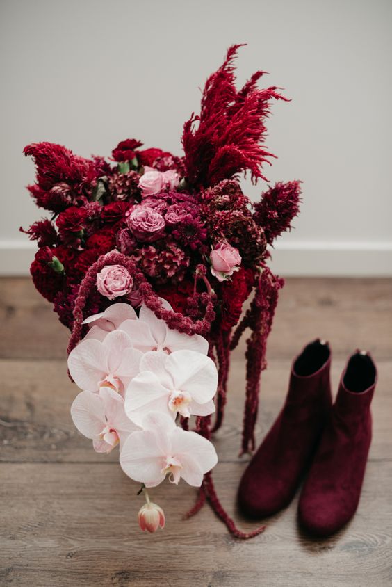 a bold and catchy wedding bouquet of pink roses, white orchids, amaranthus and burgundy pampas grass is wow