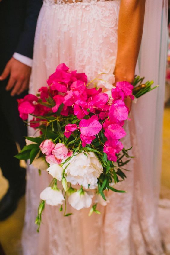 a bold bougainvillea wedding bouquet with white peonies and pink roses plus some foliage is a catchy and chic idea