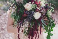 a bold forest wedding bouquet of white roses, succulents, berries, greenery and grasses plus amaranthus for a fall woodland wedding