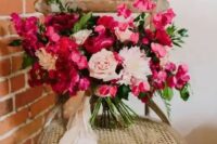 a bold fuchsia and blush wedding bouquet with much dimension and texture and blush ribbons for a Valentine wedding