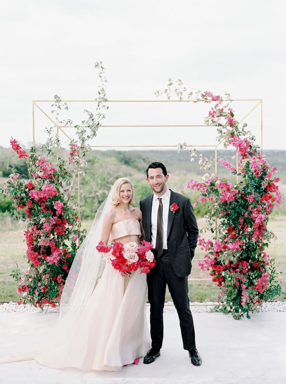 a bold modern wedding altar covered partly with ascending bougainvillea and greenery looks absolutely amazing and statement-like