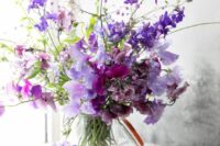 a bold purple wedding centerpiece of sweet peas is a cool idea for a spring or summer wedding, it brings the color