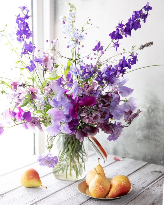 a bold purple wedding centerpiece of sweet peas is a cool idea for a spring or summer wedding, it brings the color