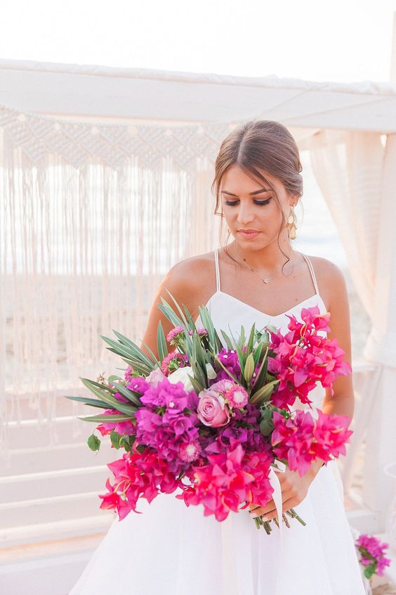 a bold tropical wedding bouquet of bougainvillea, greenery and pink and blush roses is a gorgeous idea for a tropical wedding