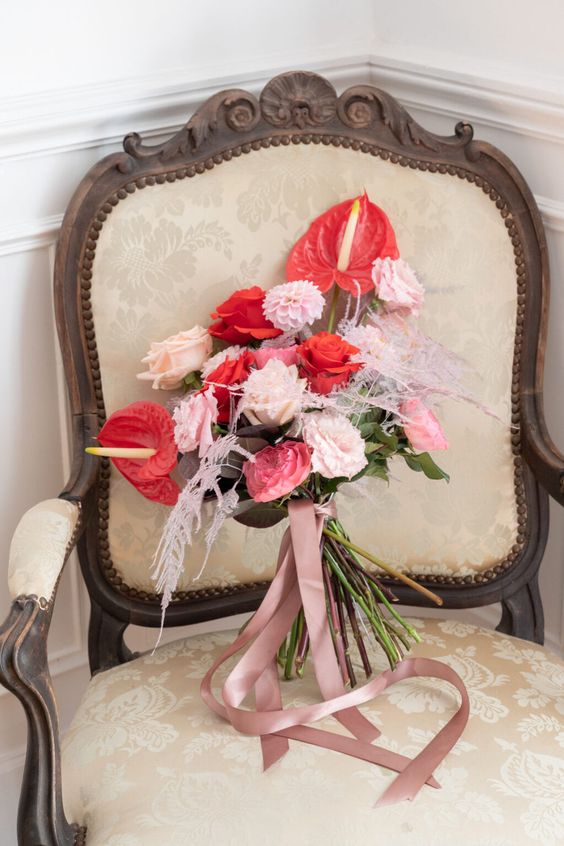a bold wedding bouquet of blush and light pink roses and mumes, red roses and anthurium plus blush grasses is a lovely idea