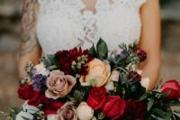 a bold wedding bouquet of peachy, red and coffee-colored roses, purple touches, thistles, greenery and amaranthus