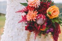 a bright fall wedding bouquet of roses, dahlias, burgundy peonies, amaranthus, greenery and berries is a cool idea