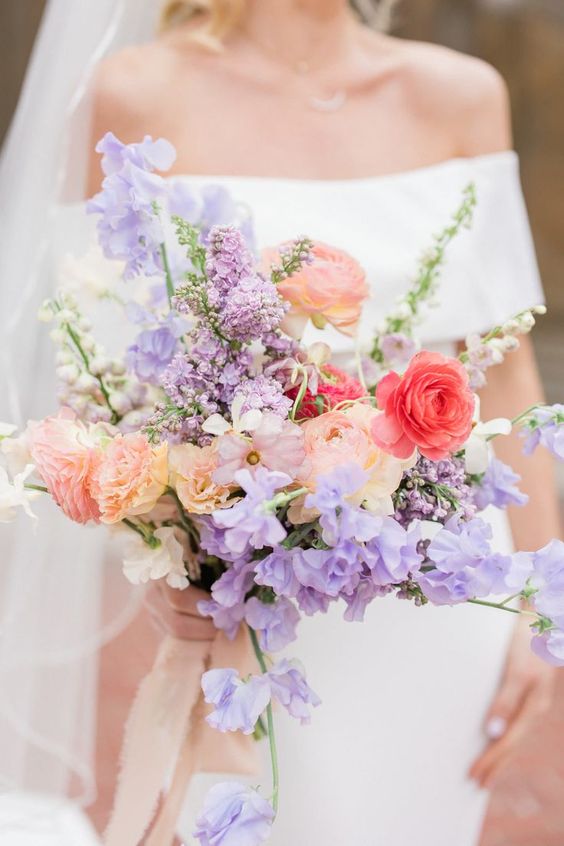 a bright summer wedding of peachy and pink ranunculus, lilac sweet peas and lilac fillers is amazing for a bright wedding