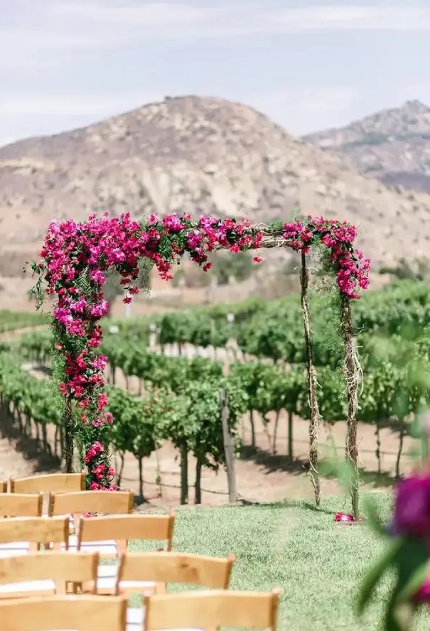 a bright wedding arch covered with magenta blooms and greenery will be a spectacular solution with plenty of color