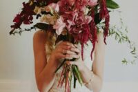 a bright wedding bouquet of blush and pink blooms, burgundy blooming branches, leaves and amaranthus is amazing for a tropical bride